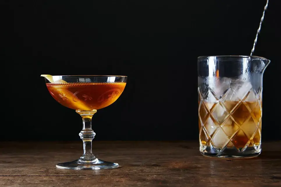 Autumn ash cocktail with a lemon peel garnish in a coupe glass