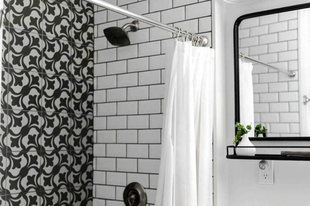 Bathroom with white subway tile, black and white accent tile, and black fixtures.