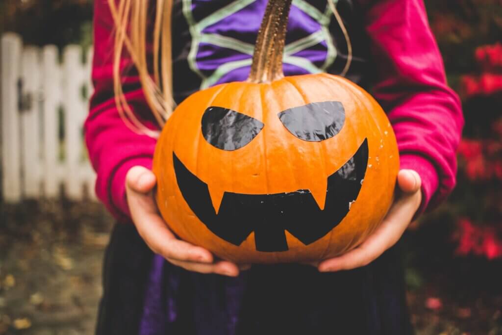 child holding a jack-o-lantern