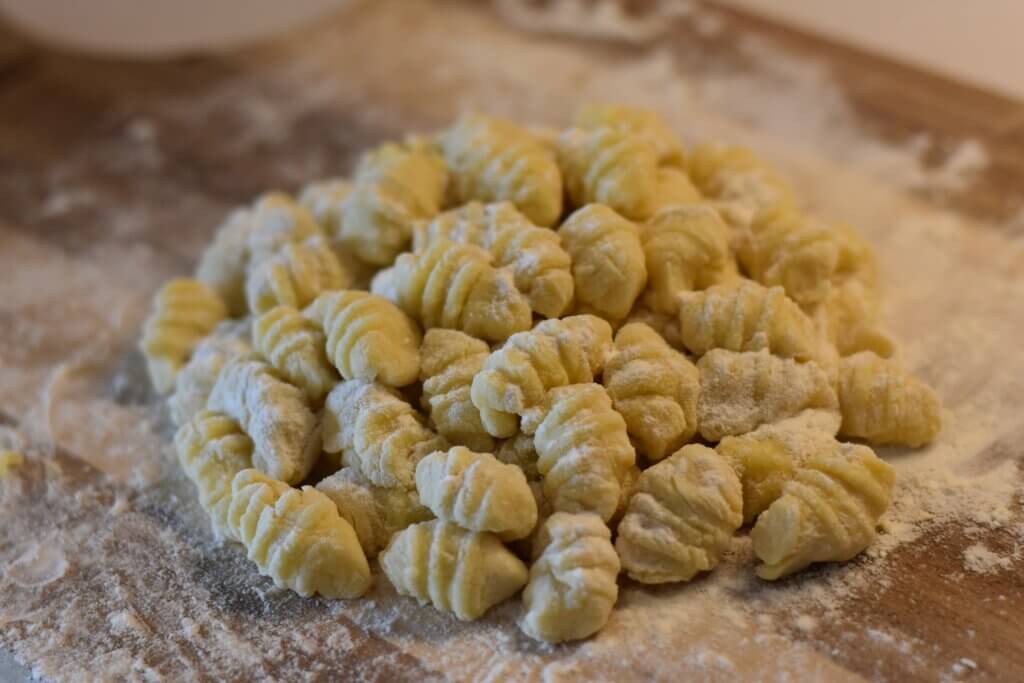Uncooked gnocchi on a wooden cutting board