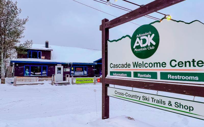 Cascade Welcome Center sign with wooden building in the background