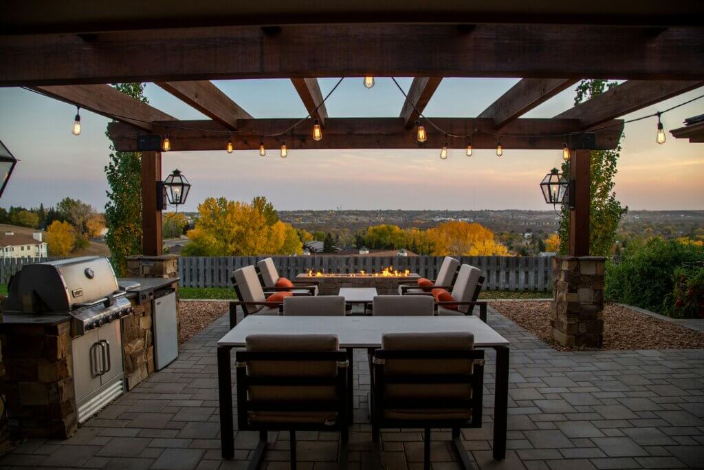 Outdoor kitchen with table under a pergola